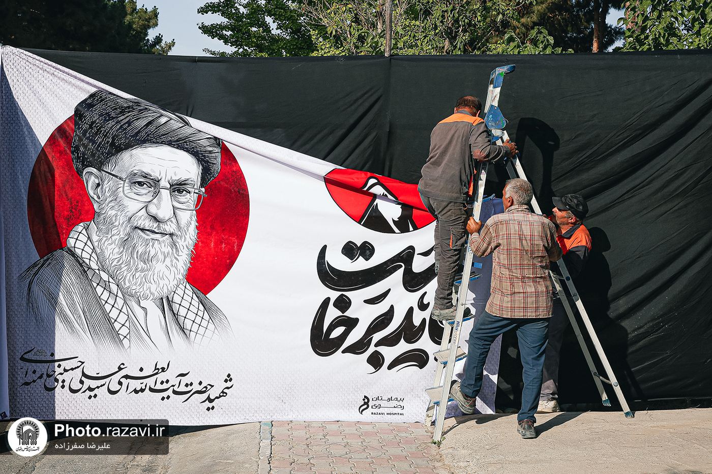 Workers mounting a portrait of the late leader