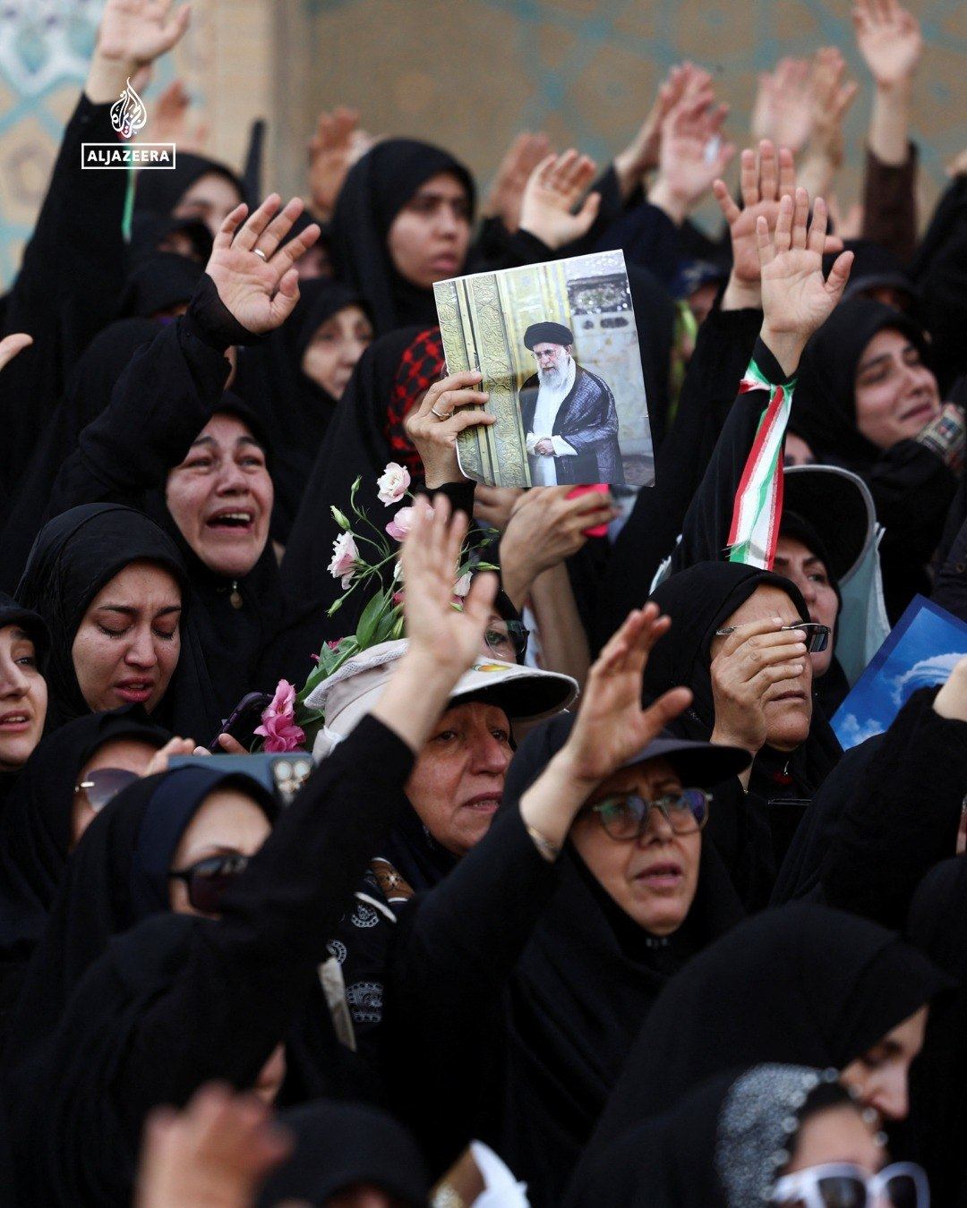 Women holding portraits of the late leader